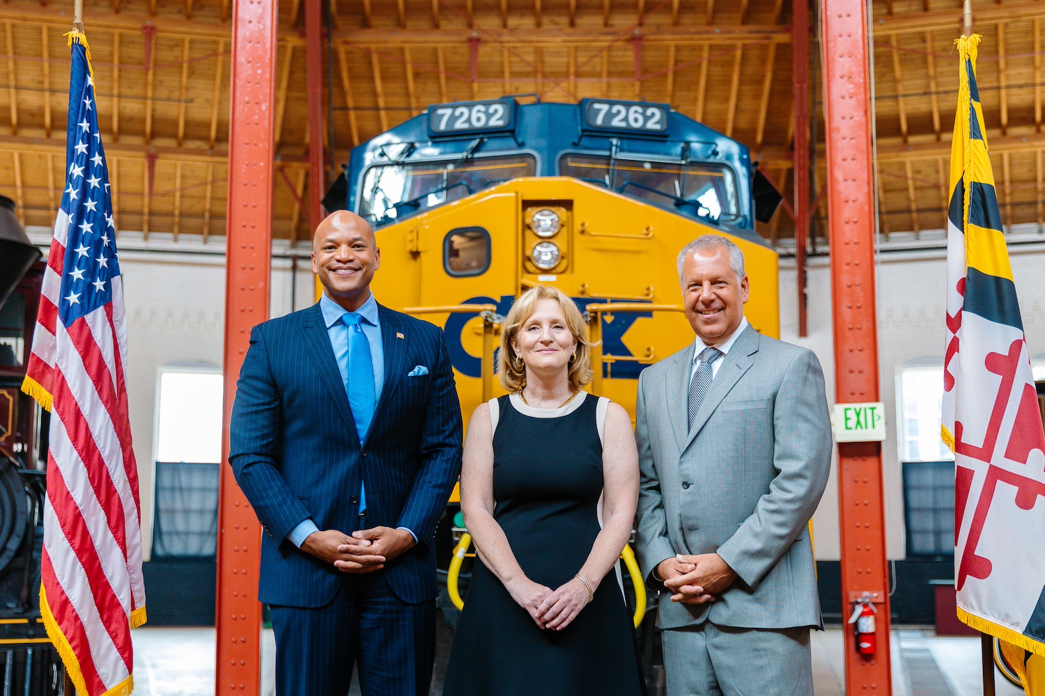 Wes Moore, Kris Hoellen, and Joe Hinrichs in front of yellow CSX train.